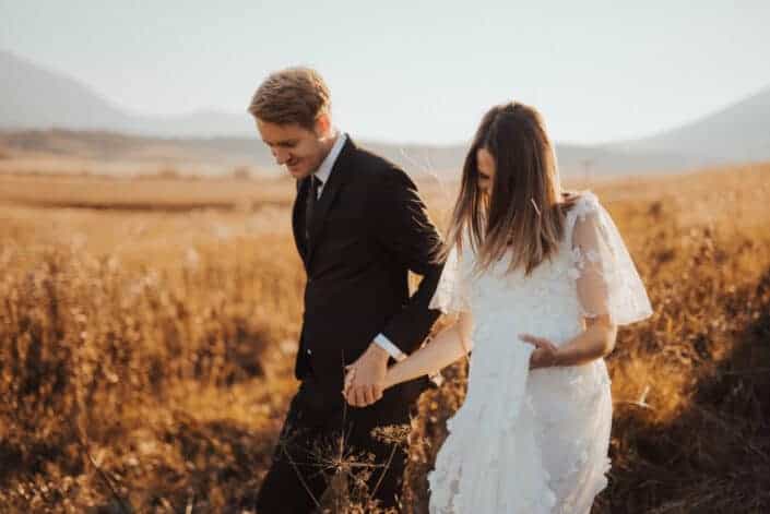 Groom and bride walking down the fields