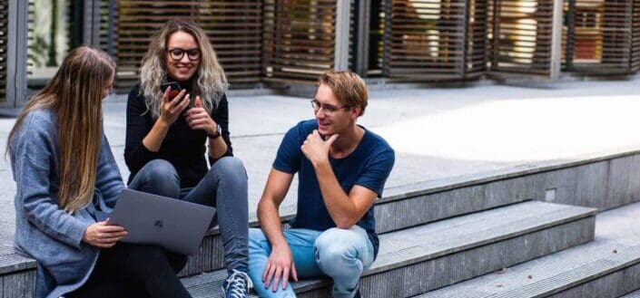 group of friends talking while using devices