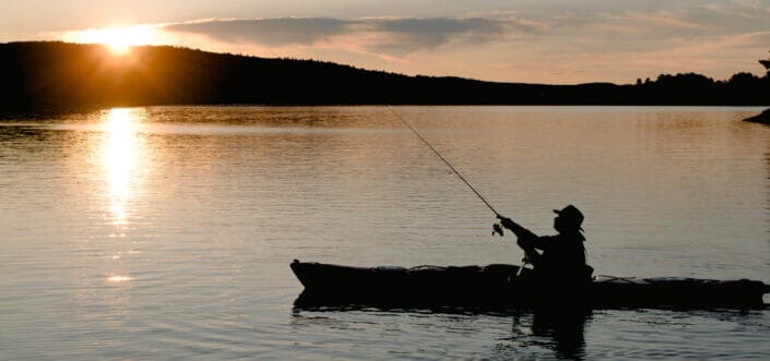 Fisherman in Boat Fishing At Sunset Lake