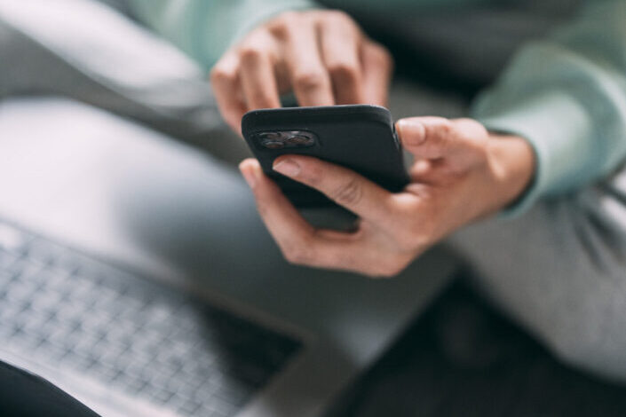 Unrecognizable man browsing smartphone on bed