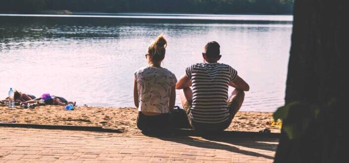 Couple sitting by the lake side 