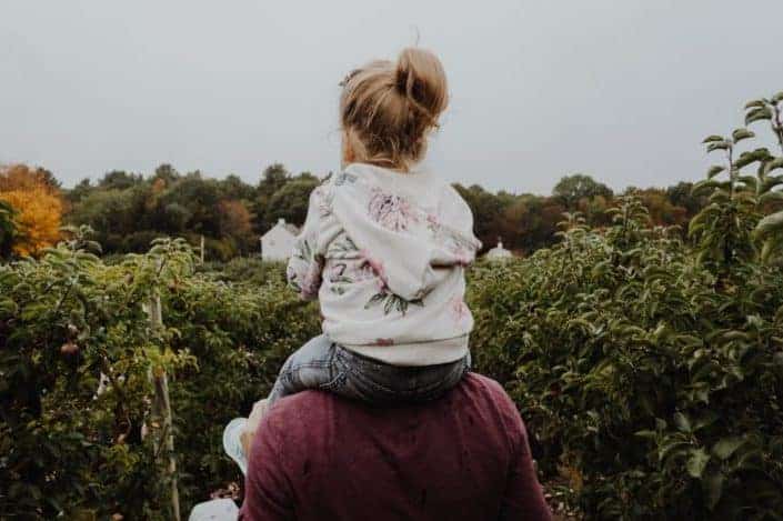 A child being carried by her father