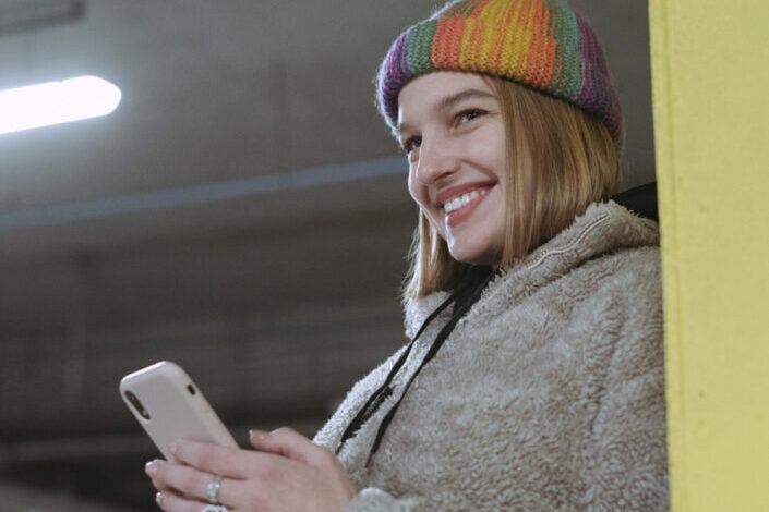 Woman smiling while holding smartphone
