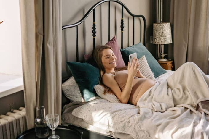 Woman texting while lying on bed