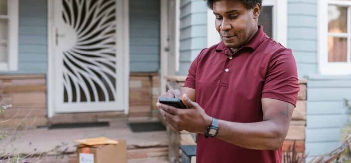 A Delivery Man Checking His Cellphone