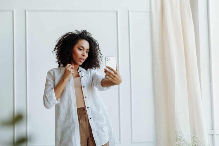 An afro haired woman taking selfie
