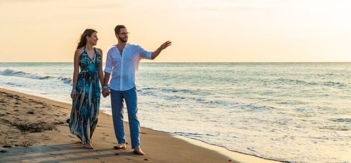 couple walking at beach during sunrise