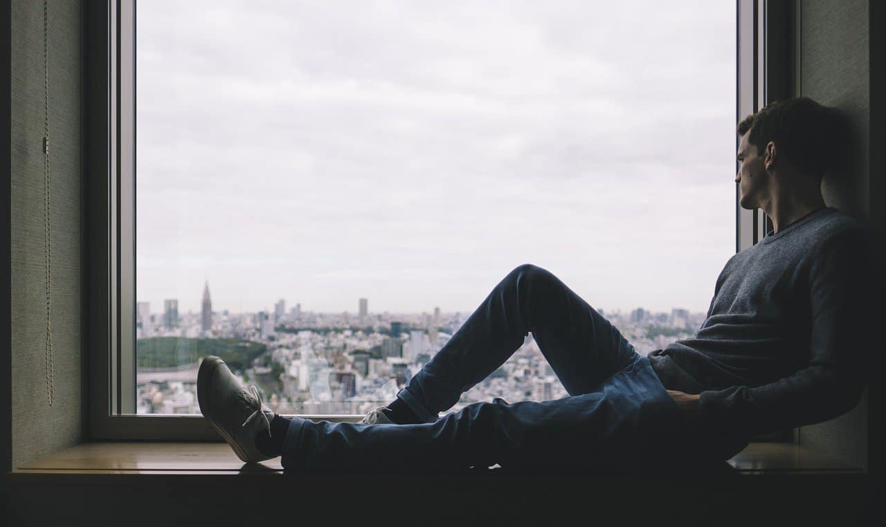 man staring out window