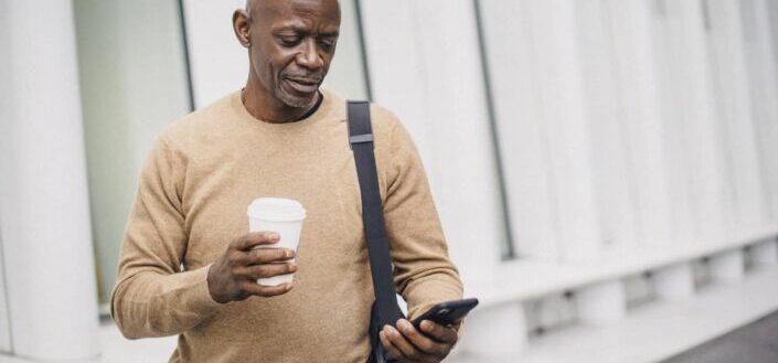 Businessman Texting on Phone in City