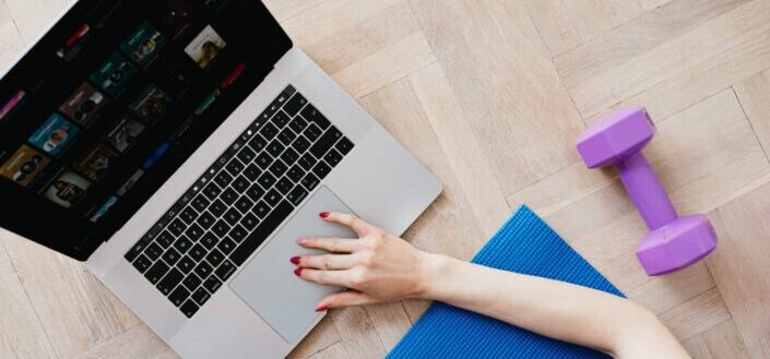 woman using laptop and dumbell