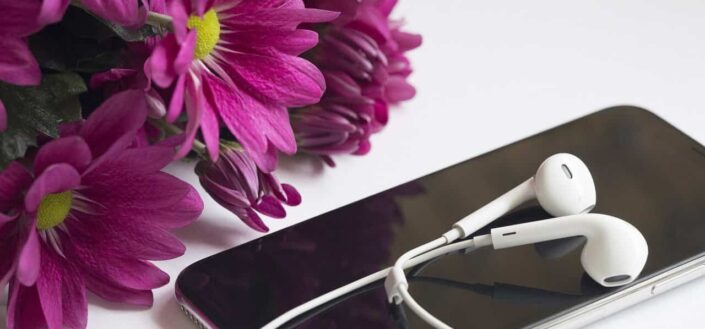 Flowers and Phone With Earphones on a Table