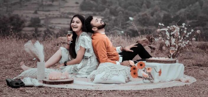 Laughing couple having picnic in field
