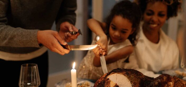 Little girl slicing the turkey
