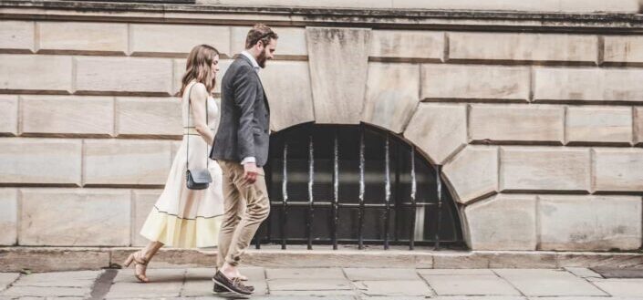 man and woman walking beside a road