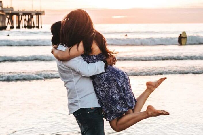 man hugging woman on seashore