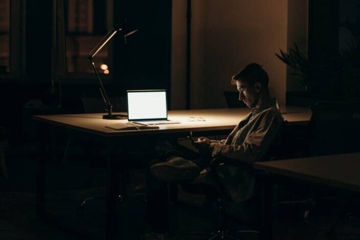 Man sitting on chair in front of macbook