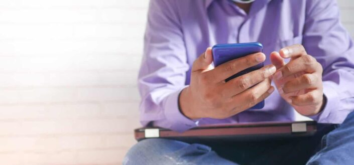 man sitting down and using phone