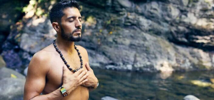 Man meditating near water