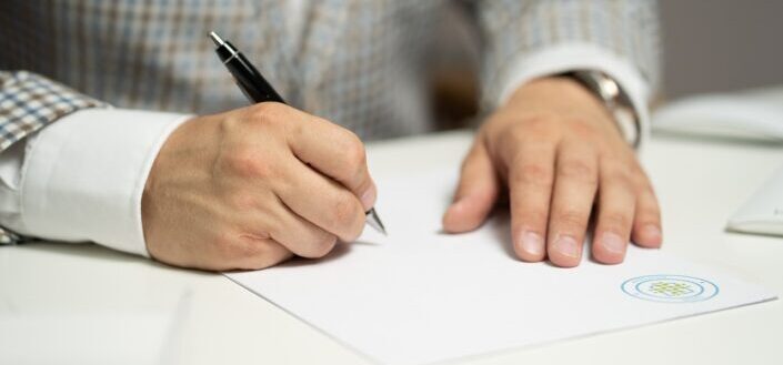 man writing on paper