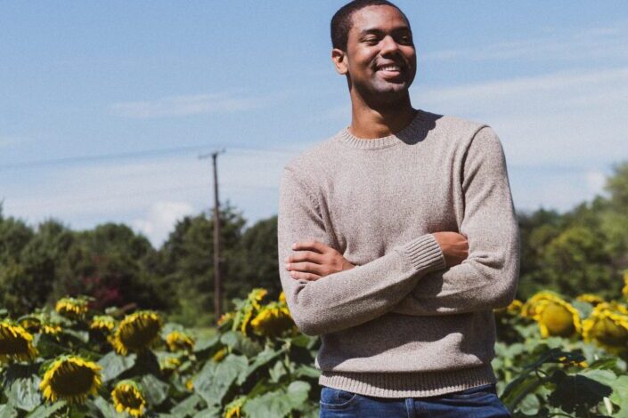 Man Smiling Near Sunflowers
