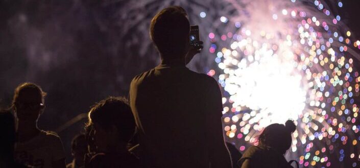 man taking picture of fireworks