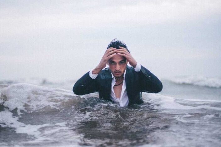 man wearing suit on a beach