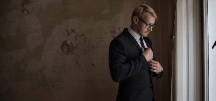 man in suit standing near window