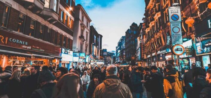 people walking on street between commercial buildings