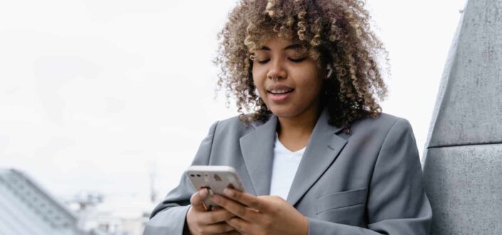 woman with an afro using cell phone