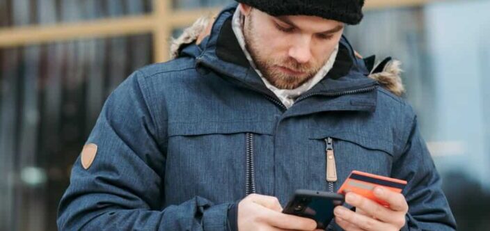 man entering his card number on phone