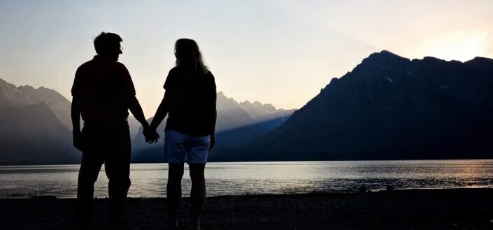 Couple holding hands beside the river