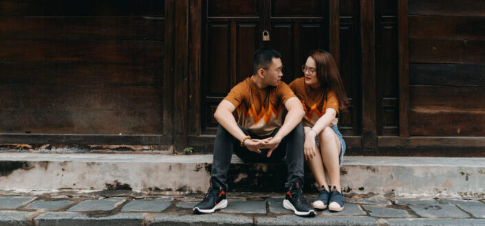 Young asian couple talking near wooden building