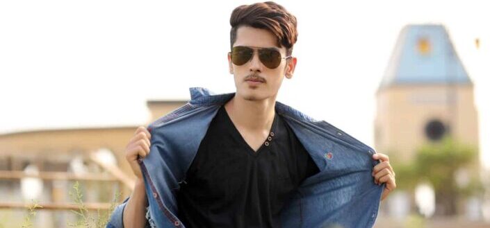 Young man in sunglasses posing outdoors