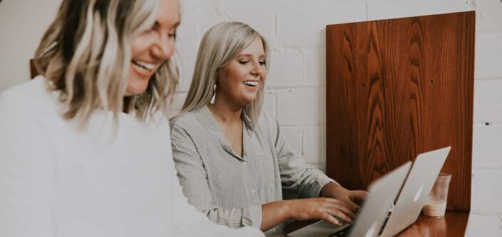 two women using laptops